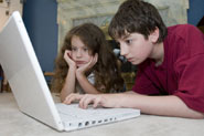 Girl and boy using laptop at home